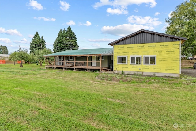 view of front facade with board and batten siding, metal roof, and a front lawn