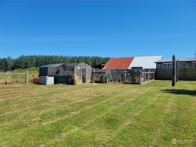 view of yard featuring an outbuilding and fence