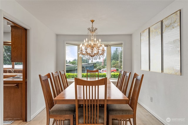 dining room featuring light wood-type flooring and a notable chandelier