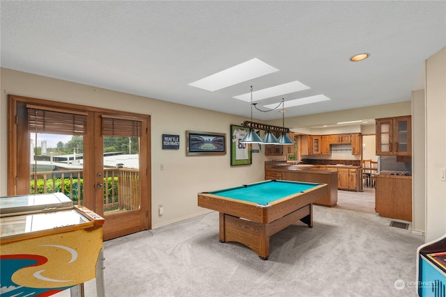 recreation room with a textured ceiling, a skylight, pool table, sink, and light colored carpet