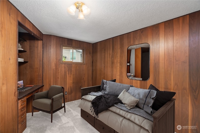 carpeted living room featuring wooden walls and a textured ceiling