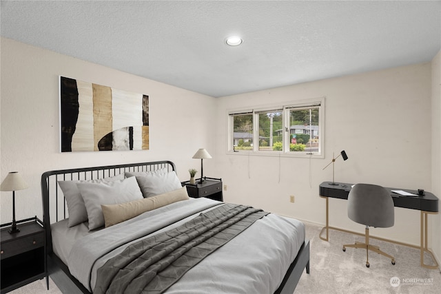 bedroom featuring a textured ceiling and light carpet