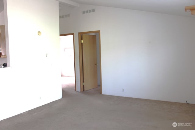 empty room with light carpet and vaulted ceiling