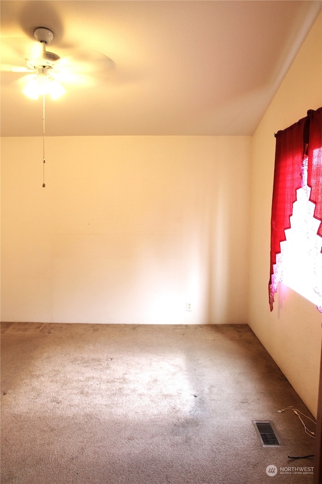 carpeted empty room featuring vaulted ceiling and ceiling fan