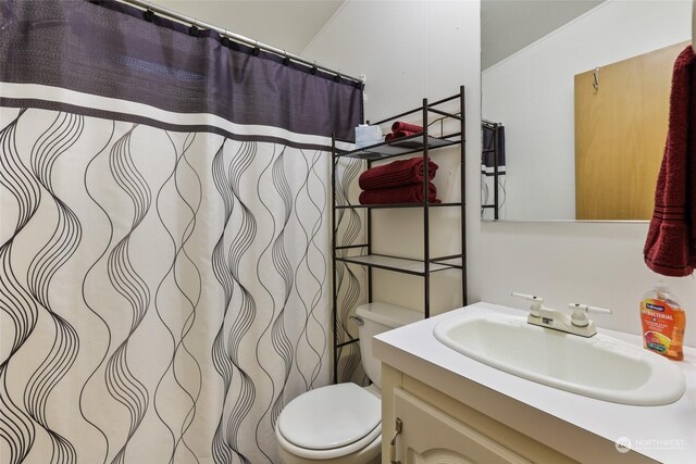 bathroom featuring a shower with shower curtain, vanity, and toilet