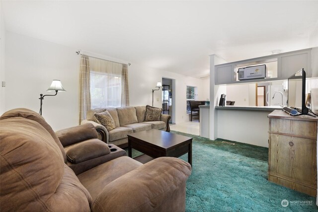 living area featuring lofted ceiling and carpet