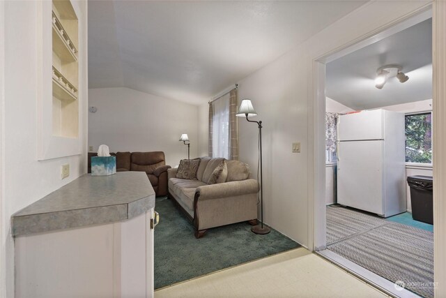 sitting room with vaulted ceiling and light carpet