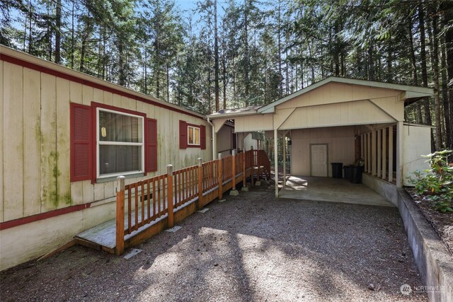 rear view of property with a carport and driveway