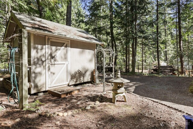 view of shed featuring fence