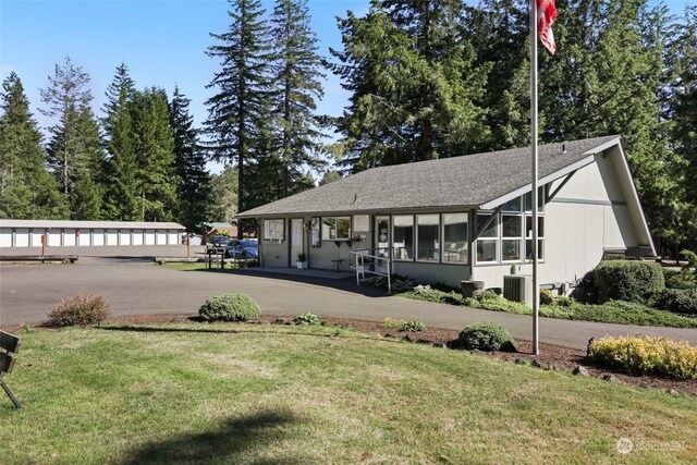 view of front of property featuring central AC and a front yard