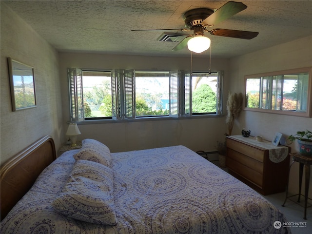 bedroom with a textured ceiling and ceiling fan