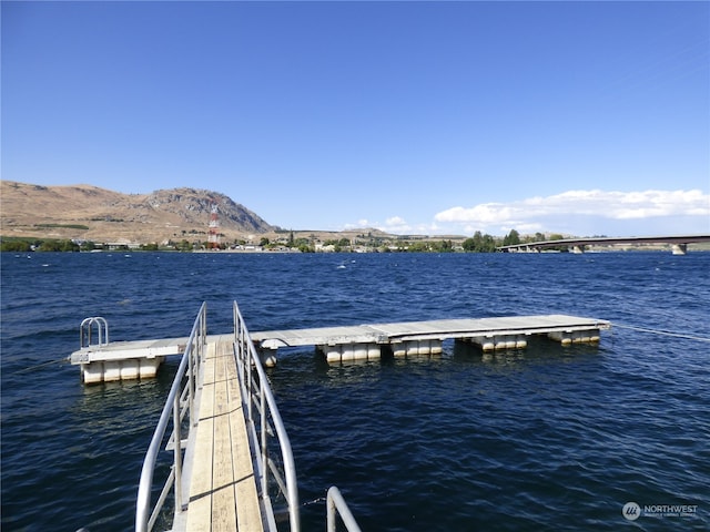 view of dock featuring a water and mountain view