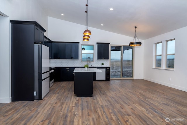 kitchen featuring appliances with stainless steel finishes, decorative light fixtures, dark hardwood / wood-style floors, and lofted ceiling