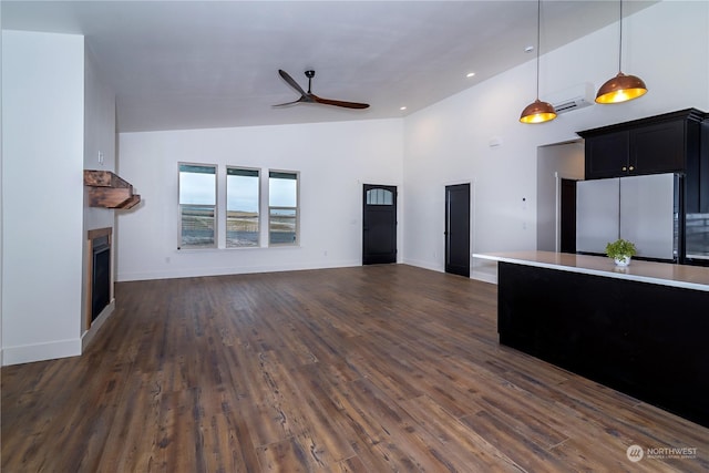 unfurnished living room featuring high vaulted ceiling, dark hardwood / wood-style floors, ceiling fan, and a wall unit AC