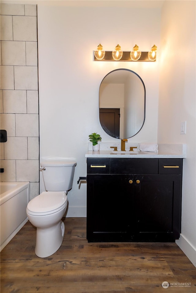 bathroom featuring toilet, vanity, and hardwood / wood-style flooring