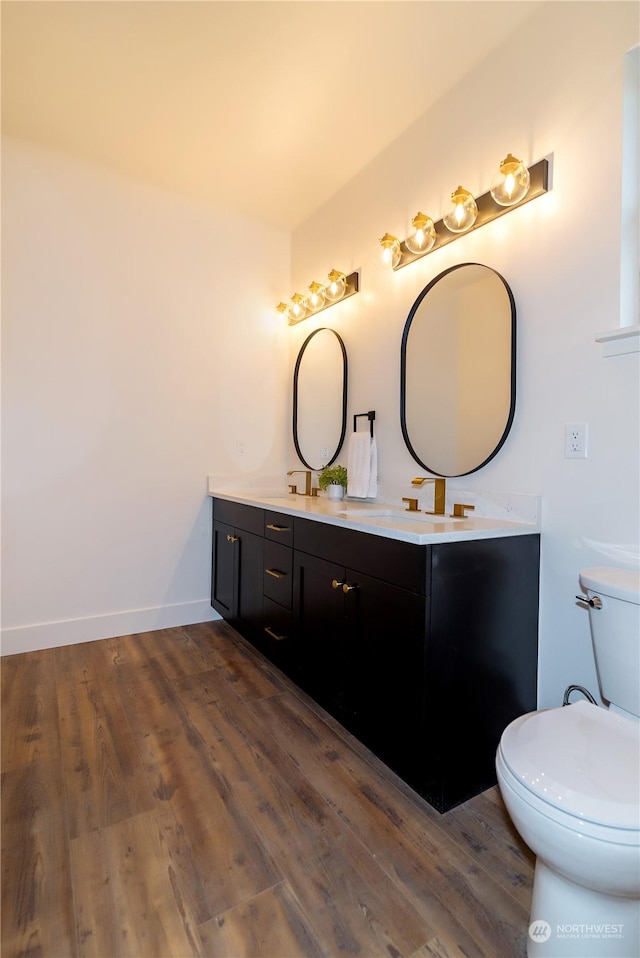 bathroom featuring vanity, hardwood / wood-style flooring, and toilet