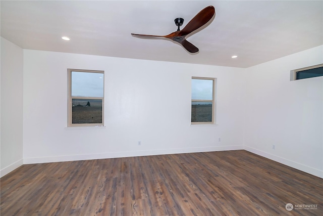 empty room with ceiling fan and dark hardwood / wood-style flooring