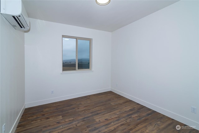 unfurnished room featuring an AC wall unit and dark hardwood / wood-style flooring