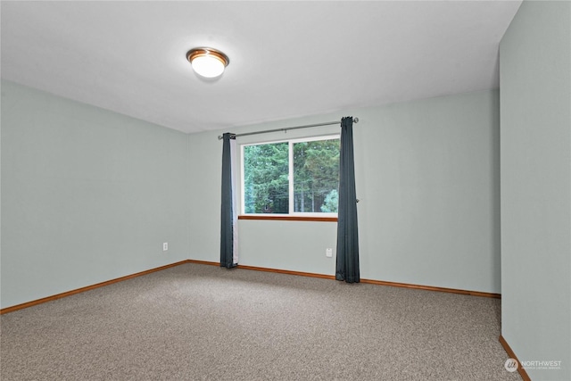 spare room featuring carpet floors and baseboards