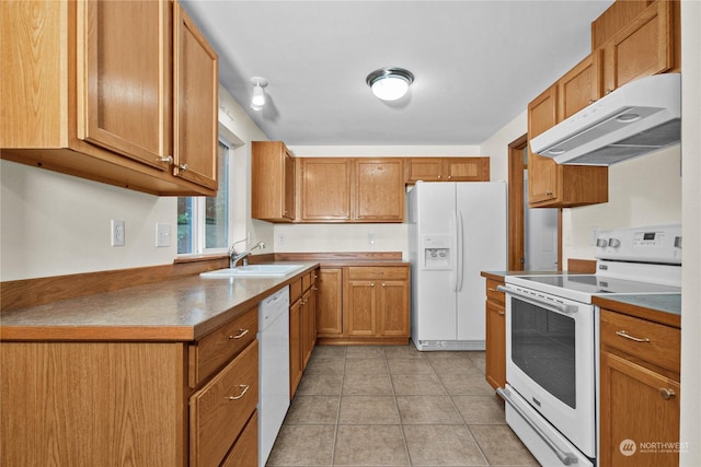 kitchen featuring light tile patterned floors, white appliances, brown cabinetry, under cabinet range hood, and a sink