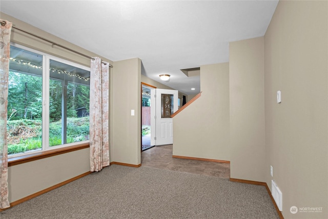 empty room featuring visible vents, baseboards, and light colored carpet