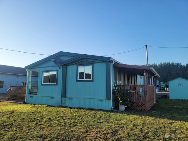 view of home's exterior featuring a wooden deck, a lawn, and a shed