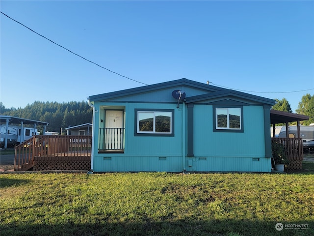 view of side of home with a lawn and a deck