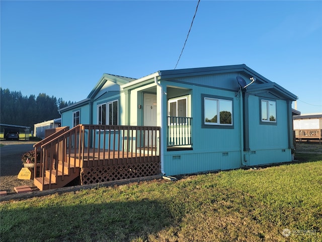 view of side of home with a yard and a deck