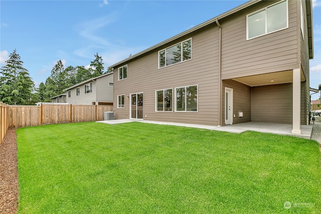 back of house featuring a yard, central AC, and a patio area