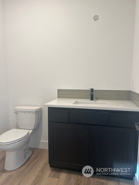 bathroom with vanity, toilet, and wood-type flooring