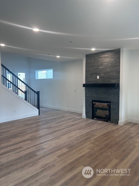 unfurnished living room featuring a large fireplace and hardwood / wood-style floors