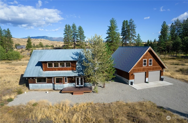 view of front of property with a garage, metal roof, an outdoor structure, and a mountain view