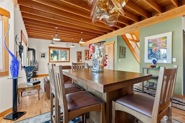 dining room with hardwood / wood-style flooring, wooden ceiling, and beamed ceiling