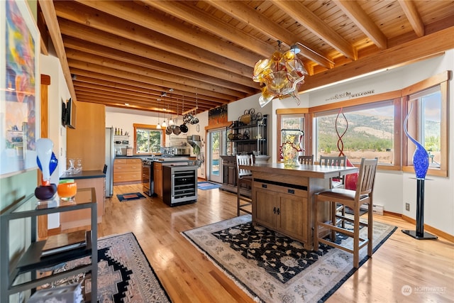 dining area with wood ceiling, plenty of natural light, beamed ceiling, beverage cooler, and a chandelier