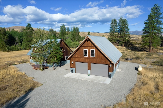 view of front facade featuring a garage, an outdoor structure, and a mountain view