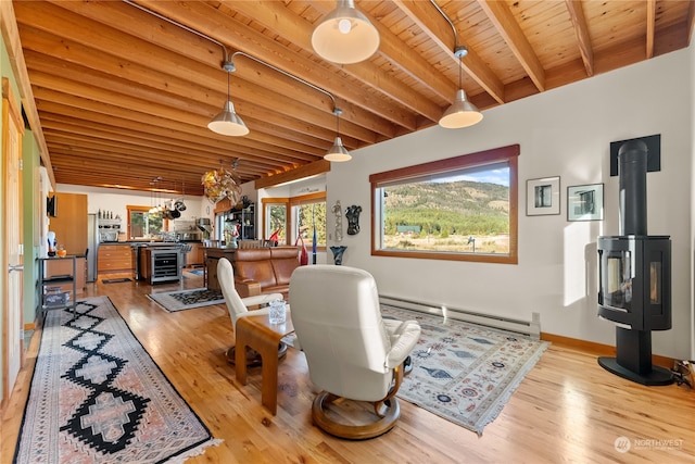 dining space featuring light wood-type flooring, a wood stove, a baseboard radiator, wooden ceiling, and beamed ceiling