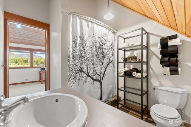 bathroom with wood ceiling, a shower with shower curtain, a sink, and toilet
