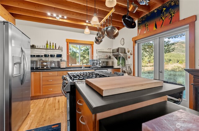kitchen with open shelves, a sink, stainless steel appliances, and beam ceiling