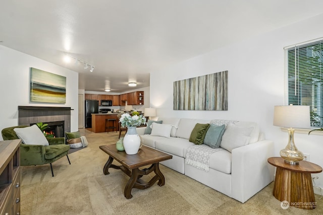 living room with a tiled fireplace and light colored carpet