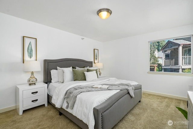 bedroom featuring light carpet and baseboards