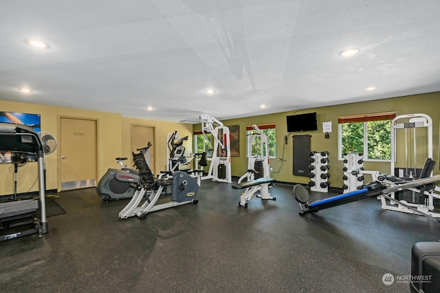 workout area with baseboards, a textured ceiling, and recessed lighting