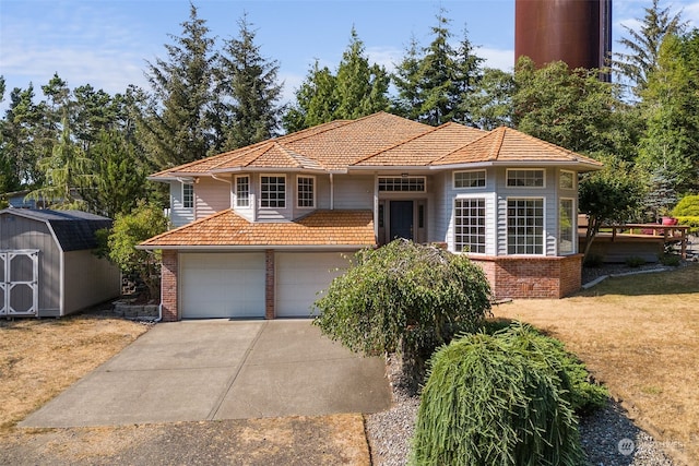 view of front facade featuring an outbuilding, a garage, brick siding, driveway, and a shed