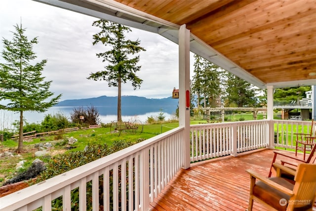 deck featuring a water and mountain view and a yard