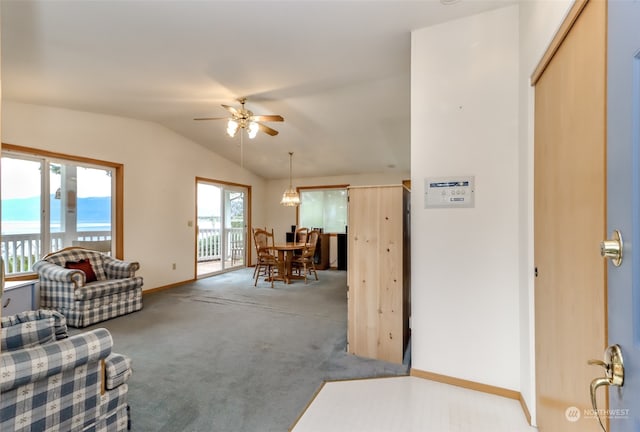 carpeted living room with a water view, lofted ceiling, and ceiling fan