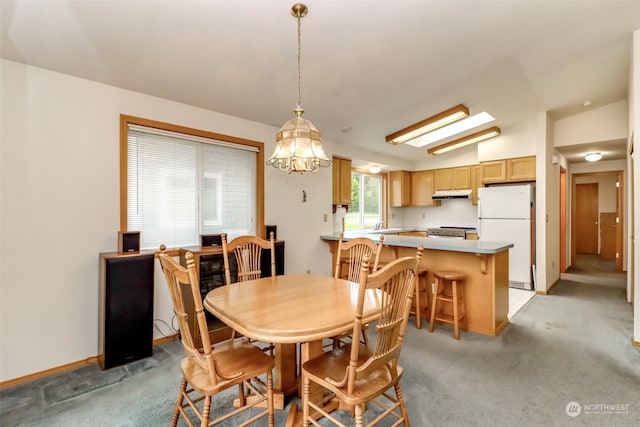 carpeted dining space featuring an inviting chandelier