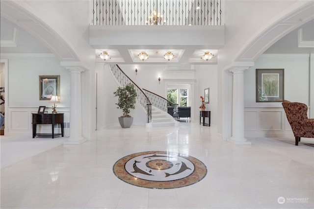 entrance foyer featuring decorative columns and crown molding