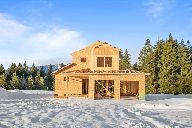 view of snow covered back of property