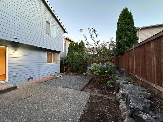 view of side of property with crawl space, a patio area, and a fenced backyard