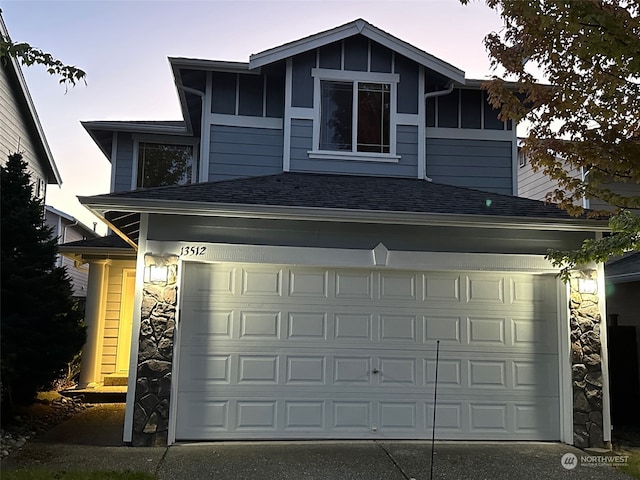 view of garage at dusk