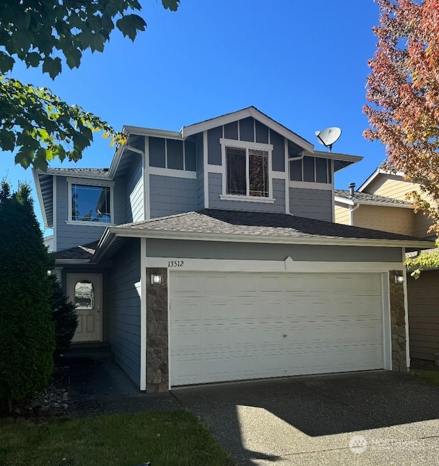 view of front of property featuring a garage, stone siding, and driveway